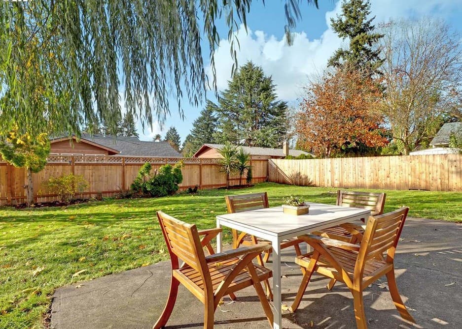 Backyard patio with a table and chairs, fenced yard