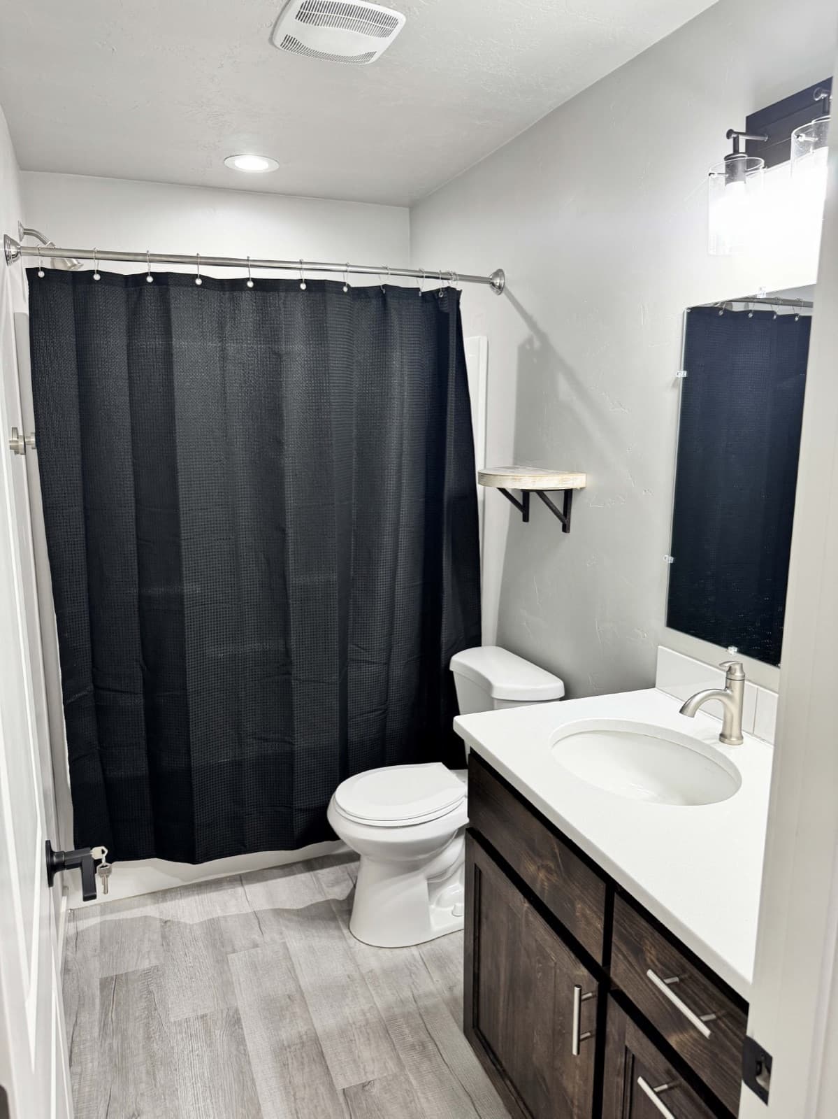 Full bathroom with a tub-shower, vanity, and mirror