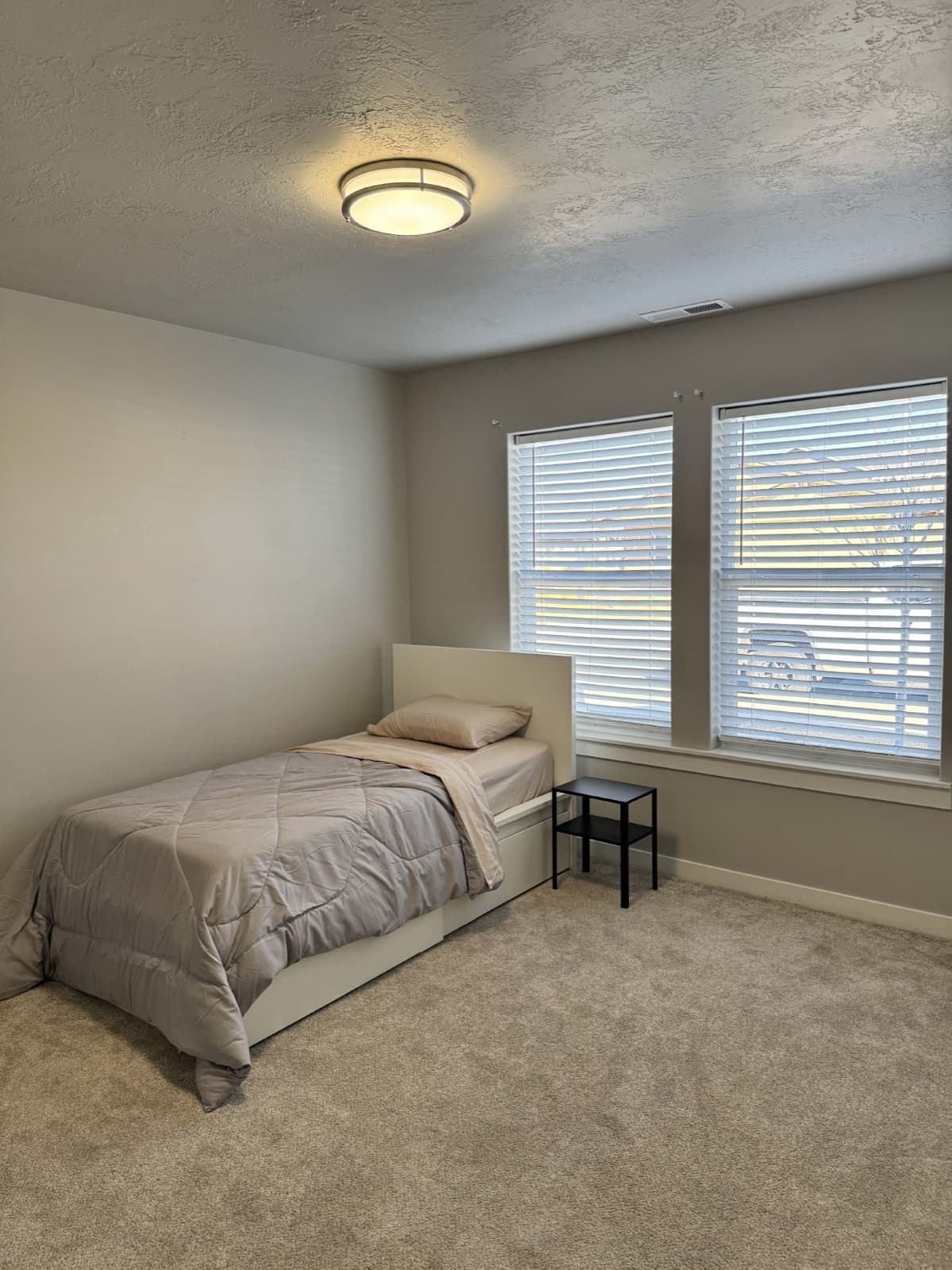 A bright bedroom with a bed and large windows