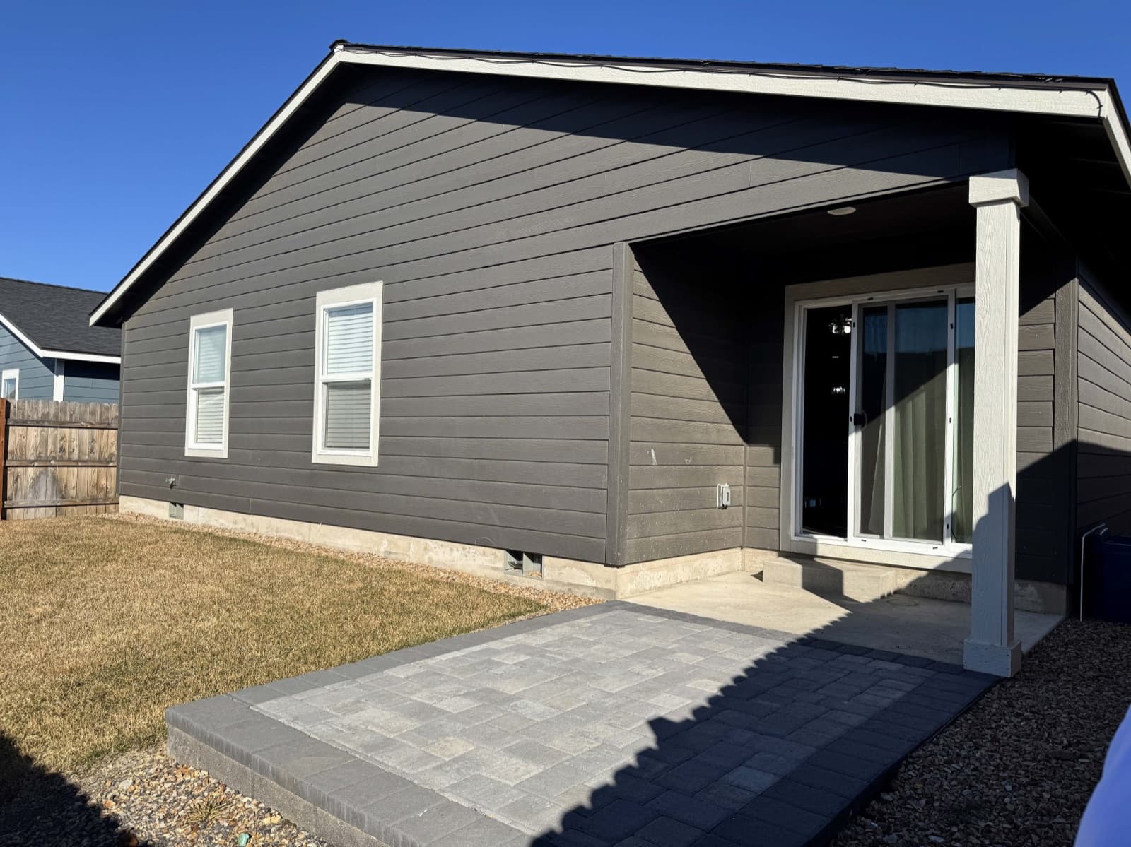 Back of the house with a paved patio and a fenced yard